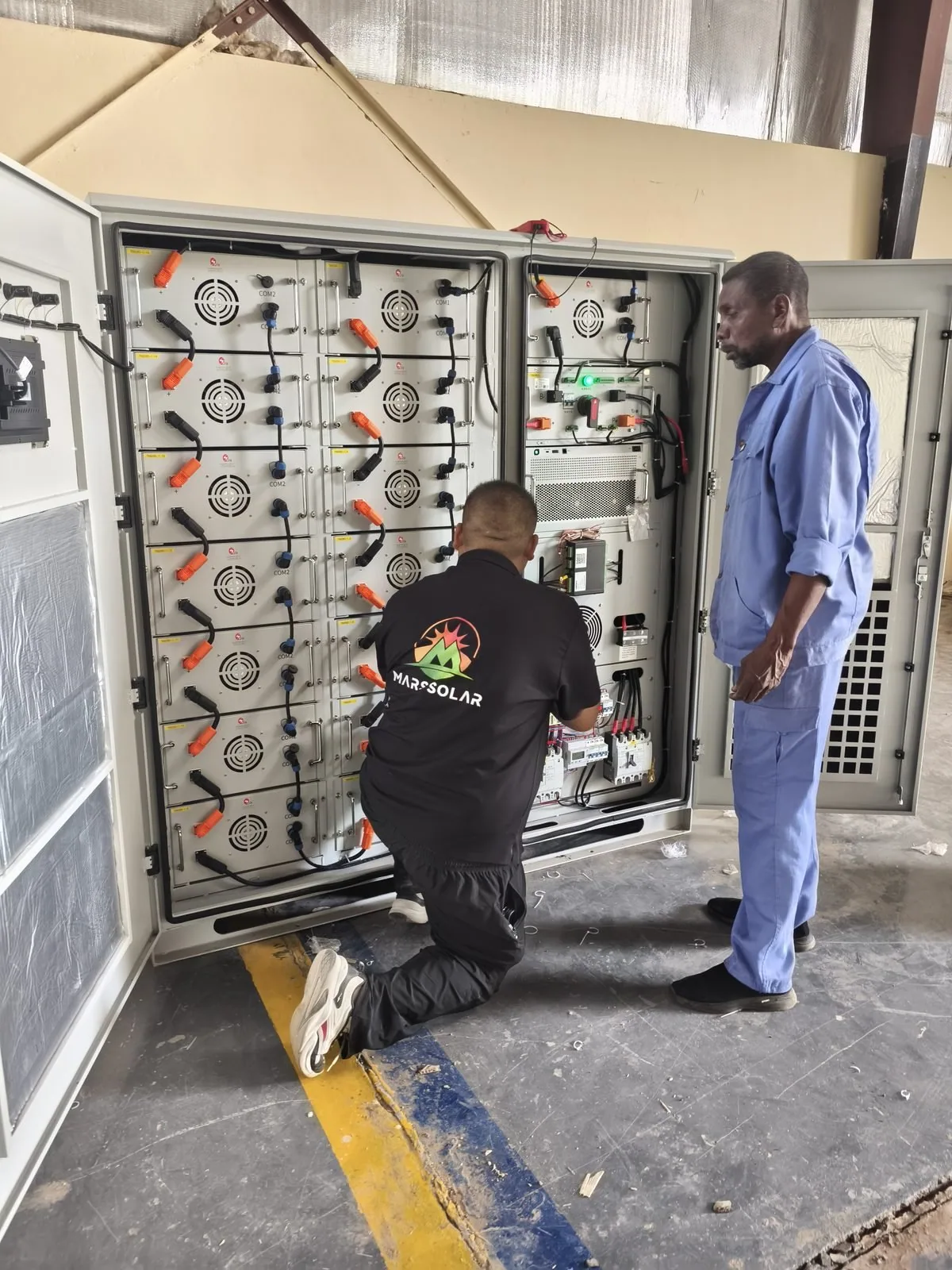 Technicians installing the battery cabinet at the wastewater facility